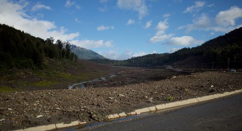 Scenic view of road by mountains against sky