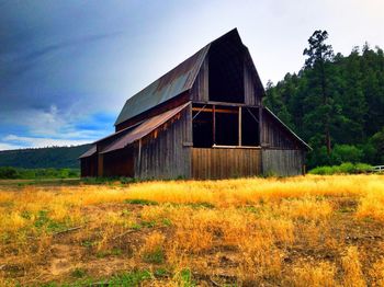 Abandoned house on field against sky