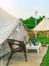 Holiday tents and lounge areas on green lawn place among trees at natural parkland. 