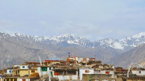 Houses on snowcapped mountains against sky