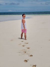 Full length of boy on beach against sky