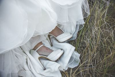 Low section of woman wearing high heels on grass