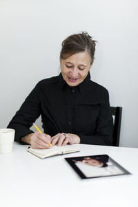 Senior woman writing in notebook