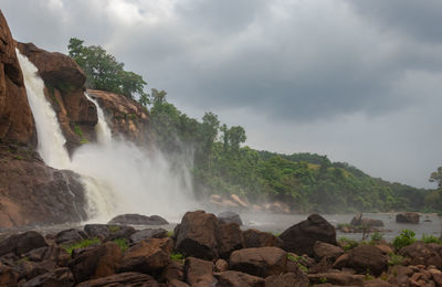 Waterfall with cloudy sky and green forests of the western ghat range