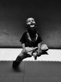 Smiling boy sitting on floor at home