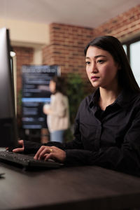 Portrait of young woman using laptop at table