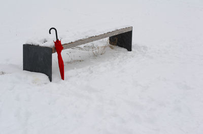 Red umbrella on snow covered field