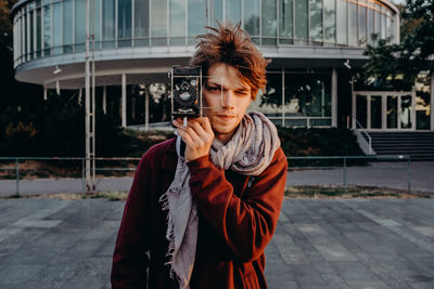 Portrait of young man looking at city