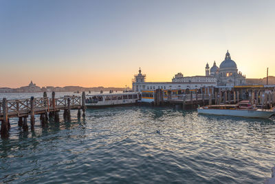 View of canal in city at sunset