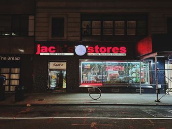 Information sign on street in city at night