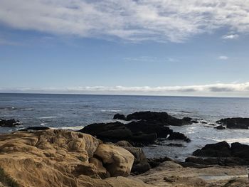 Scenic view of rocks on beach against sky