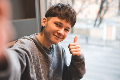 Portrait of young man gesturing outdoors