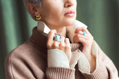 Cropped picture fashion woman in brown oversize sweater with stylish accessories