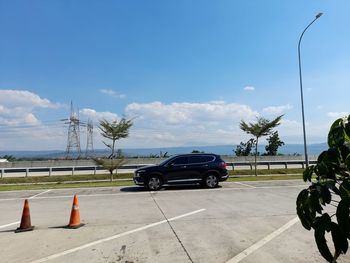 Cars on road against blue sky