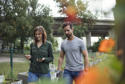 Mid adult couple walking in community garden