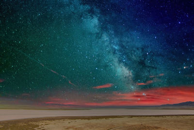 Scenic view of sea against star field at night