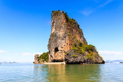 Rock formation in sea against sky