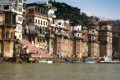 Buildings by sea against sky in city