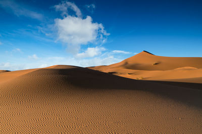 Scenic view of desert against blue sky