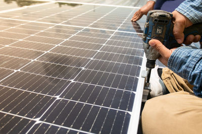 Low angle view of man working against sky