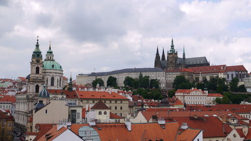 View of church in town against cloudy sky