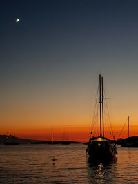 Silhouette sailboat on sea against sky during sunset