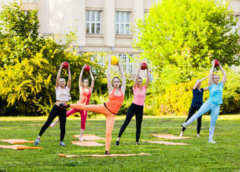 Woman with arms raised in park