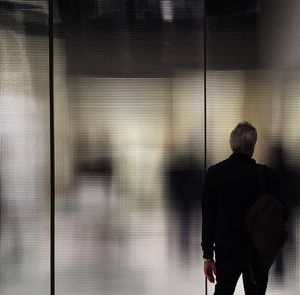 Rear view of a man standing in office