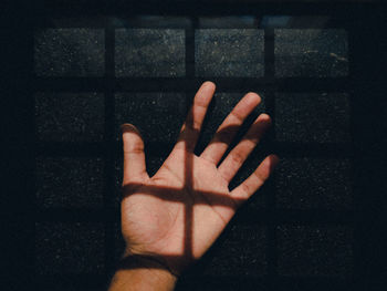 Close-up of hand touching shadow on wall