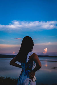 Woman looking at sea against sky