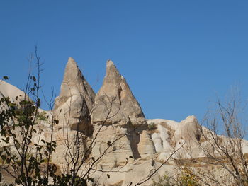 Low angle view of rock formation against clear blue sky