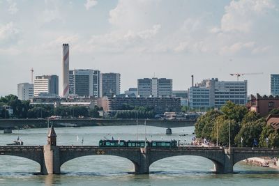 Bridge over river in city against sky