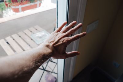 Cropped hand of man by door at home