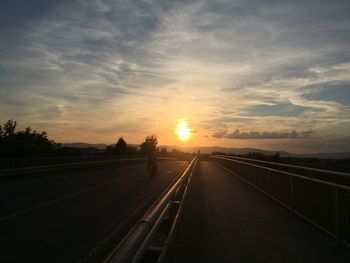 Empty country road against orange sky