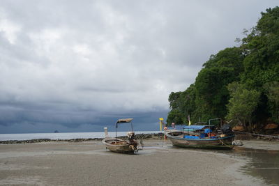 Boats moored on beach against sky