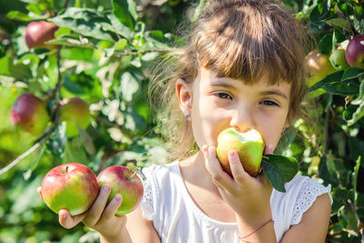 Portrait of young woman holding fruit