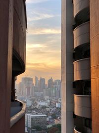 Modern buildings in city against sky during sunset