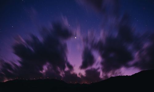 Low angle view of silhouette mountain against sky at night