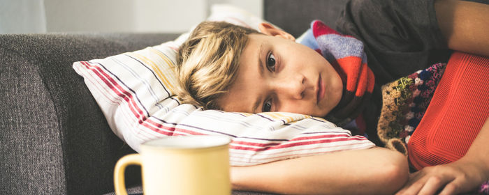 Portrait of boy lying on sofa at home