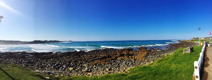 Panoramic view of sea against clear blue sky