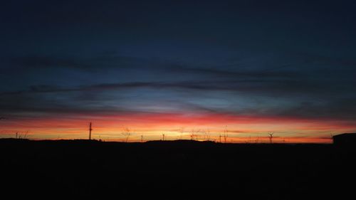 Scenic view of silhouette field against sky at sunset