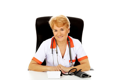 Portrait of woman sitting against white background