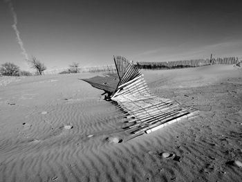 Abandoned fence on sandy beach