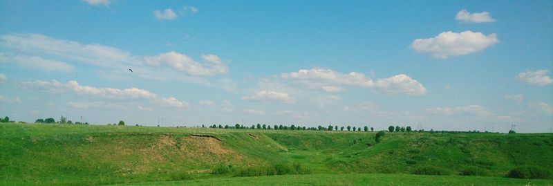 Scenic view of grassy field against cloudy sky