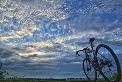 Man cycling on bicycle against sky