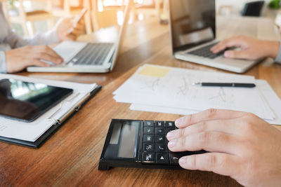 Midsection of man using laptop on table