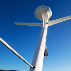 Low angle view of wind turbine against blue sky