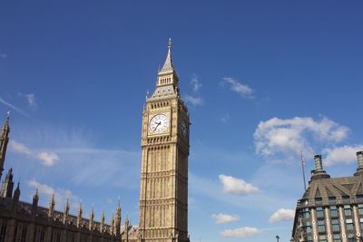 Low angle view of clock tower amidst buildings in city