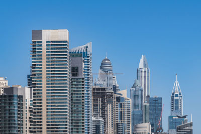 Skyscrapers in city against clear blue sky