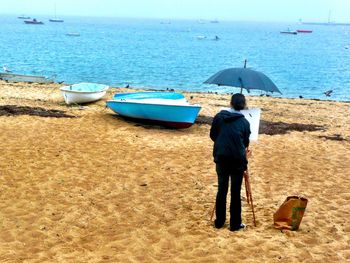 Rear view of man standing on beach